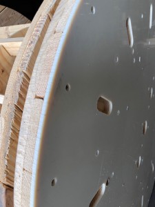 Wooden flange with smooth acrylic covering leaning against a regular wooden flange for comparison